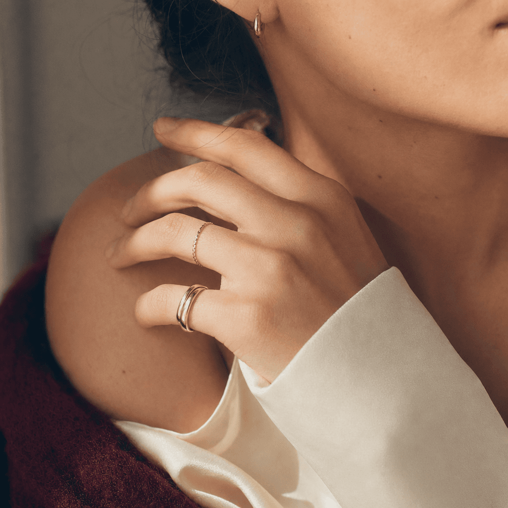 Gold jewellery at the collarbone over cream silk